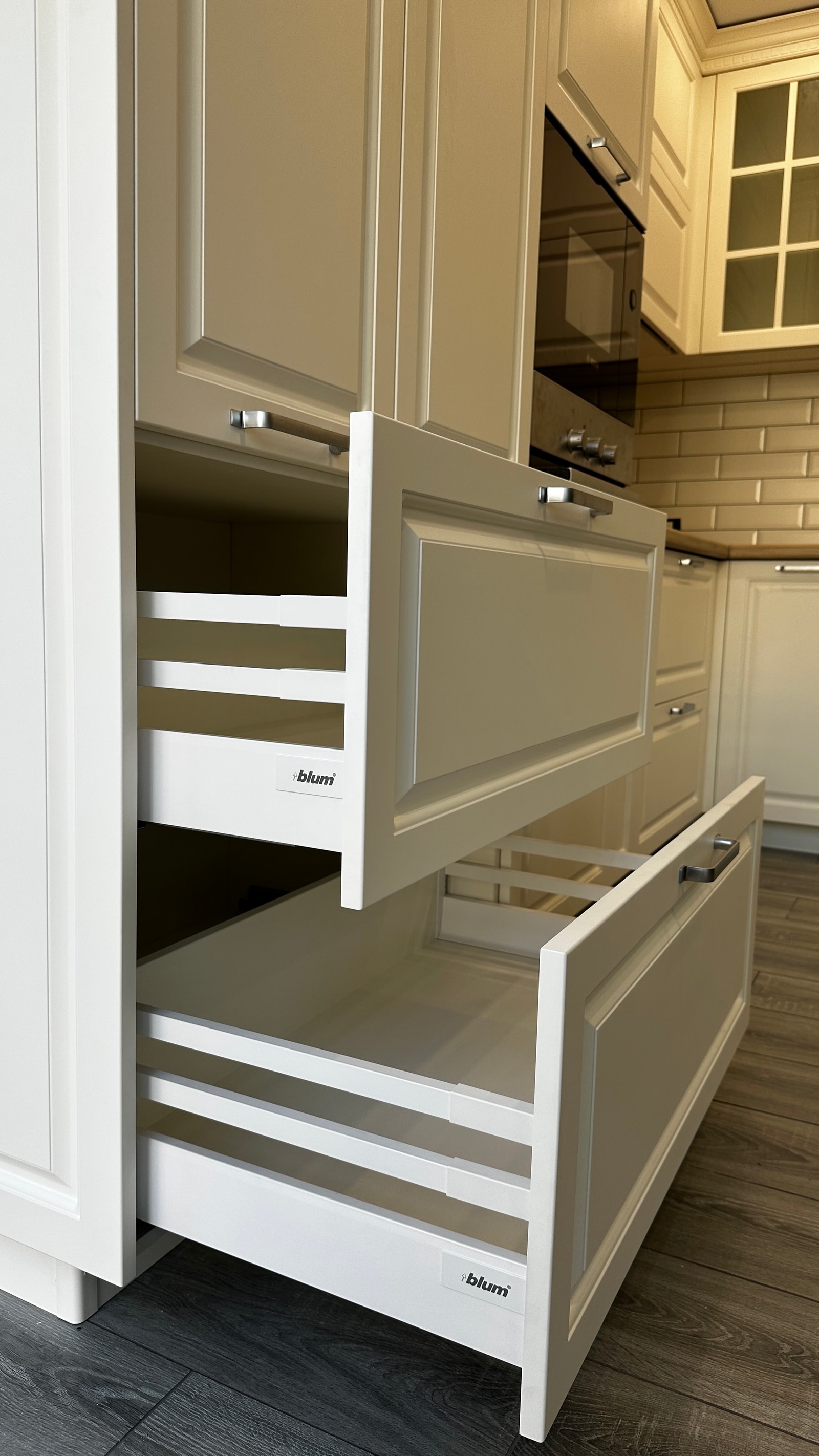Выдвинутые ящики Blum в бежевой кухне с филёнчатыми фасадами