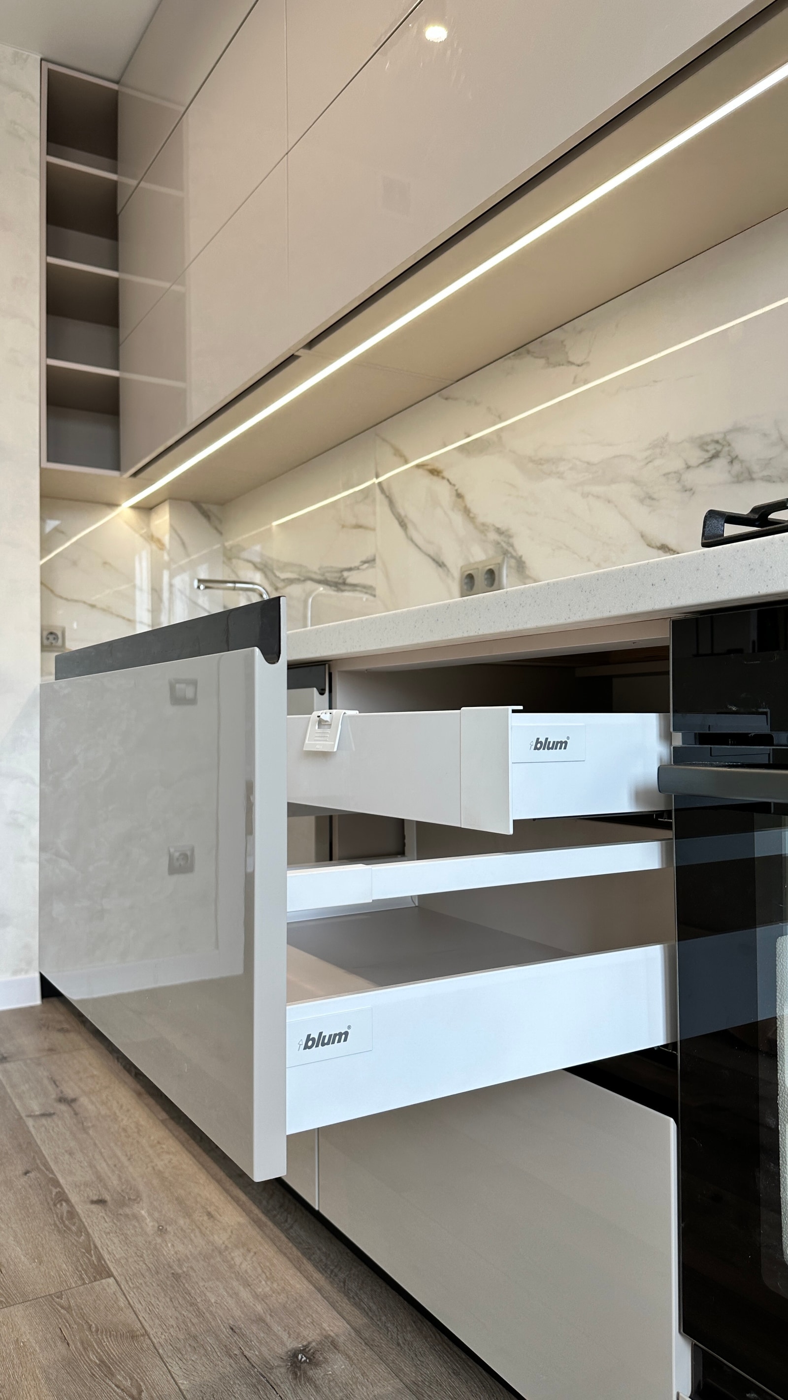 Крупный план выдвинутых белых ящиков Blum в кухонном гарнитуре