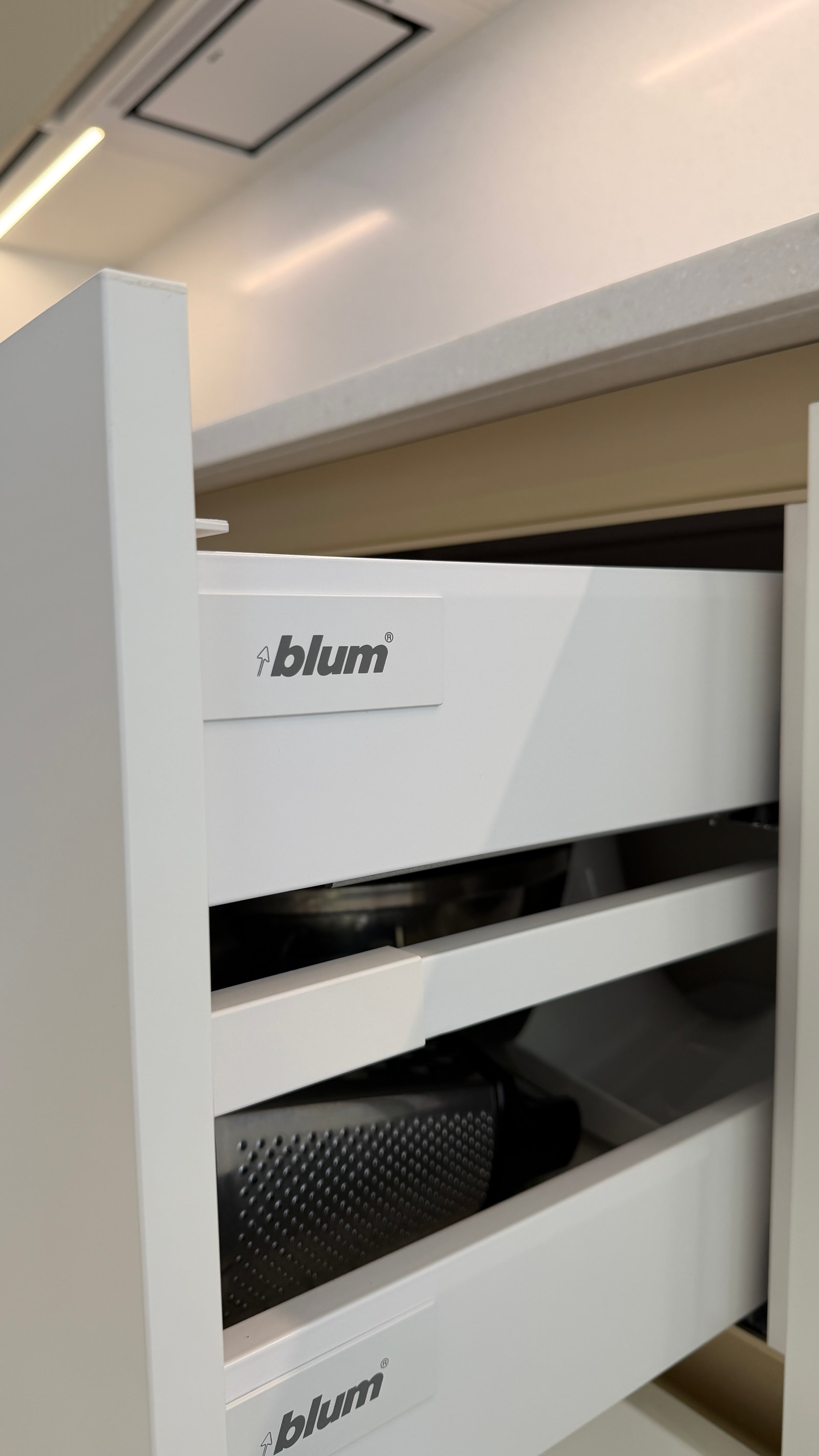 Открытый нижний шкаф кухни с выдвижными ящиками Blum Legrabox, внутри сковороды и органайзер, светлая столешница под мрамор